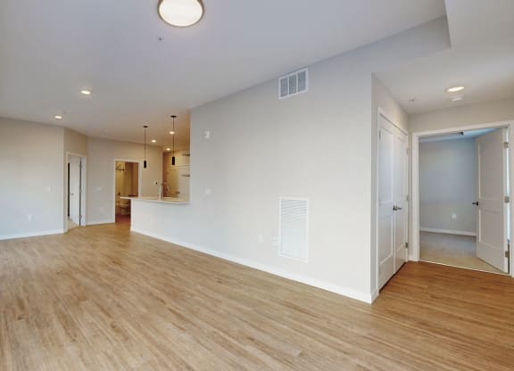 the living room and dining room of an empty house with wood flooring