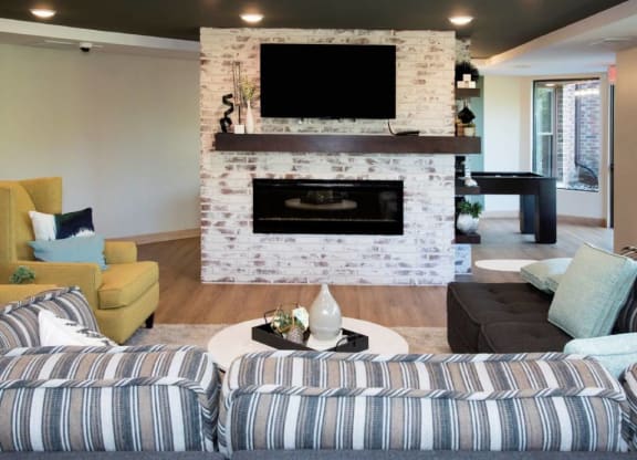 Couch, fireplace, tv, lounge in community room at Aspenwood Apartments, Eagan, MN