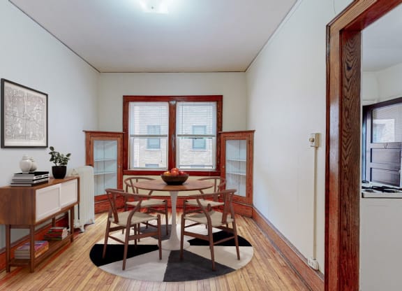 a dining room with a table and chairs and a window