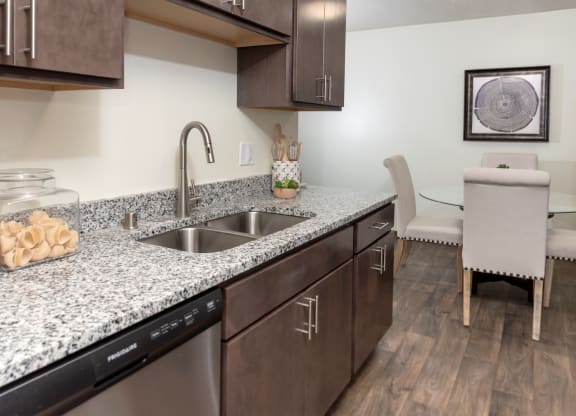 a kitchen with granite countertops and a stainless steel sink