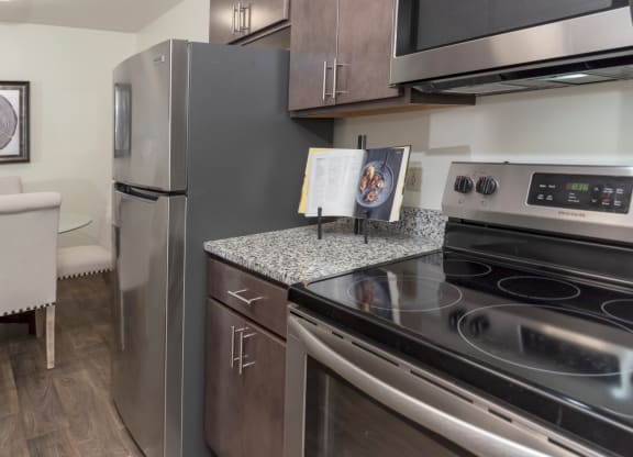 a kitchen with stainless steel appliances and a granite counter top and a stainless steel refrigerator