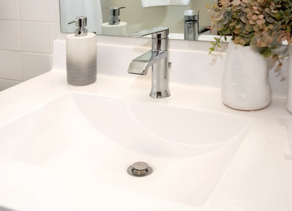 a white sink with a silver faucet in a bathroom