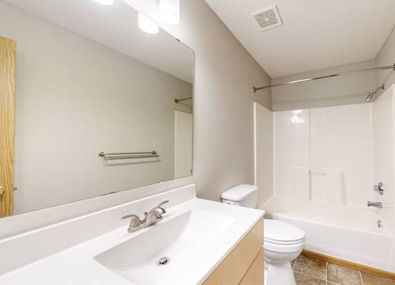 A bathroom with a white sink, toilet, and bathtub.