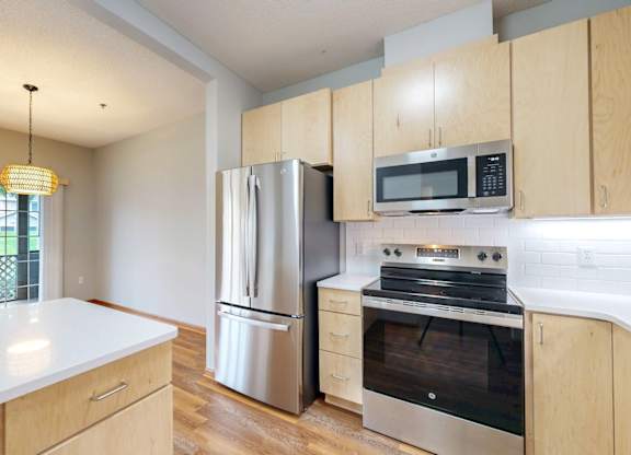 A kitchen with wooden cabinets and stainless steel appliances.