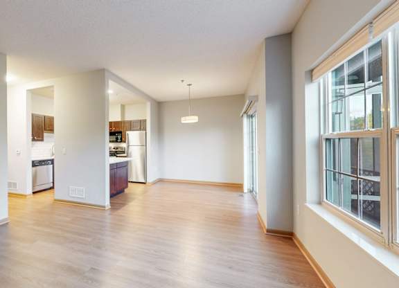 A kitchen area with a dining table and chairs is visible through the window.