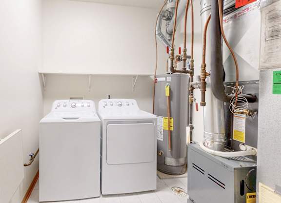A wall-mounted washer and dryer are installed in a small utility room.