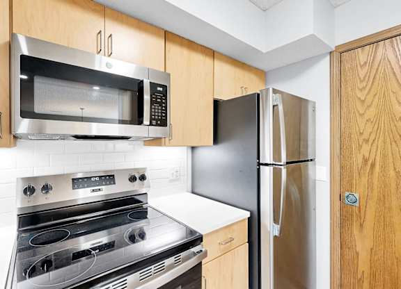 A kitchen with a stove, oven, microwave, and refrigerator.
