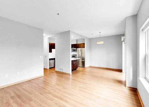 A large empty room with wooden floors and white walls.