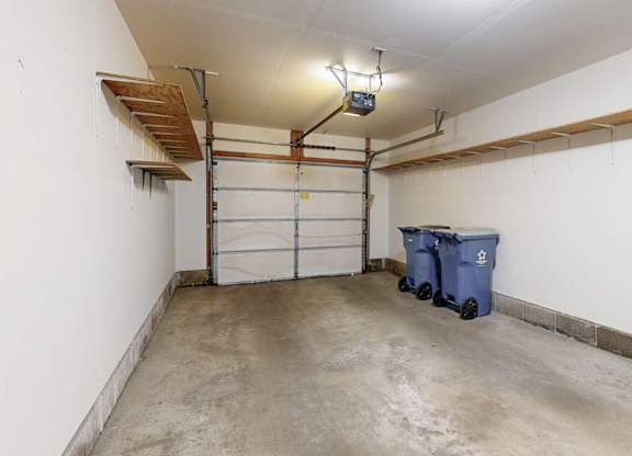 A white wall with a white door and a light on the ceiling.