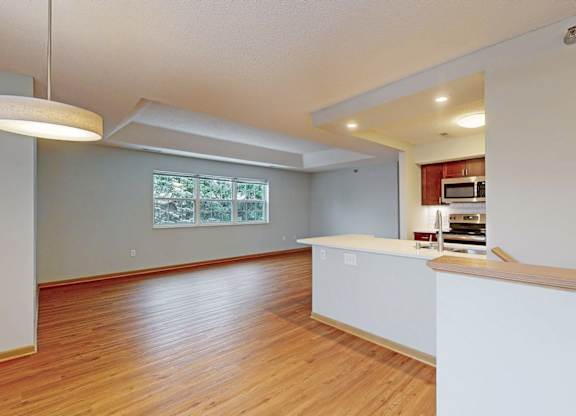 A kitchen with a white counter and wooden floors.
