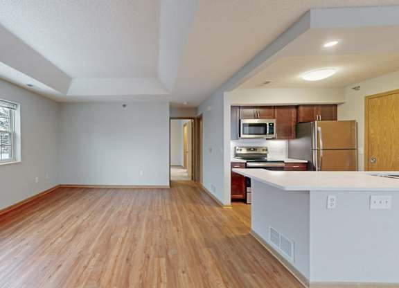 A large empty room with wooden floors and white walls.