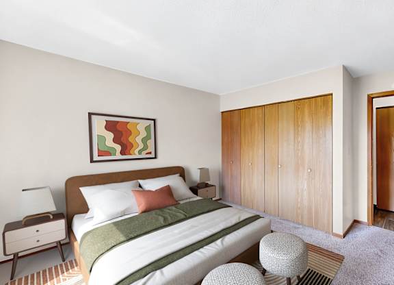 A bedroom with a bed, nightstand, and wardrobe.