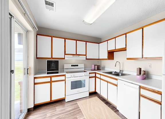A kitchen with white cabinets and a white refrigerator.