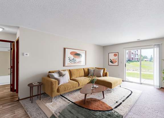 A living room with a yellow couch and a coffee table.