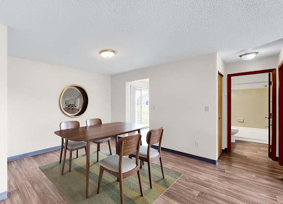A dining room with a table and chairs.
