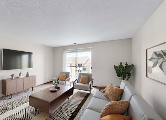 A living room with a grey couch, a brown coffee table, and a flat screen TV mounted on the wall.