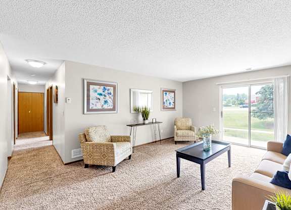 A living room with a couch, chairs, and a coffee table.