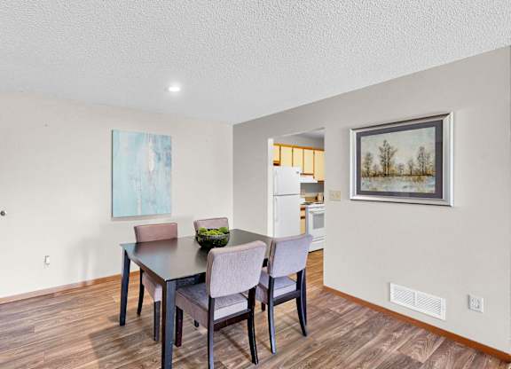 A dining room with a wooden table and chairs.