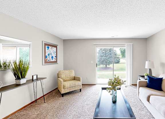 A living room with a couch, chair, and a painting on the wall.