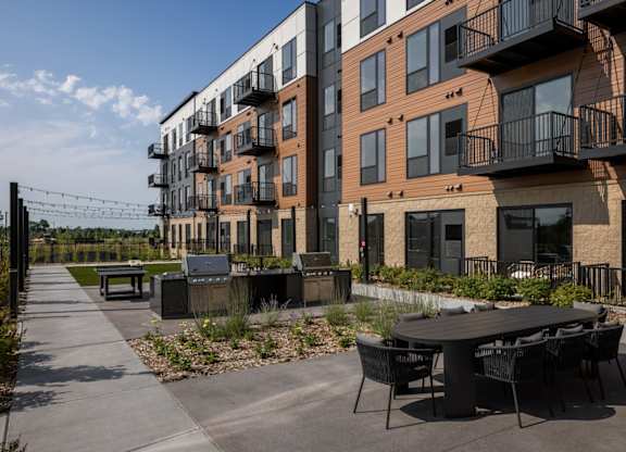 A modern apartment complex with a patio area in front.