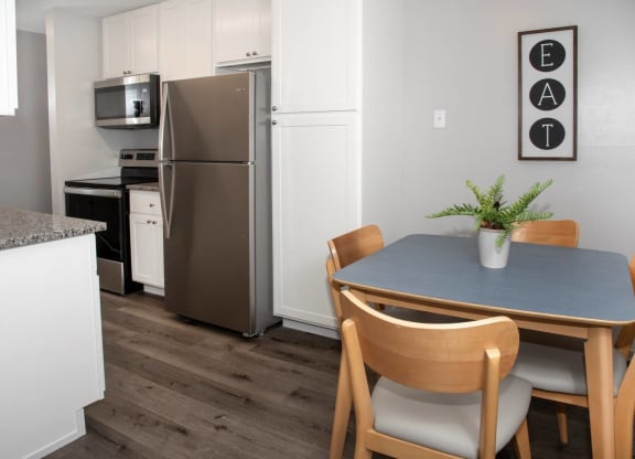 kitchen and dining with new white cabinetry, granite countertops, stainless steel appliances