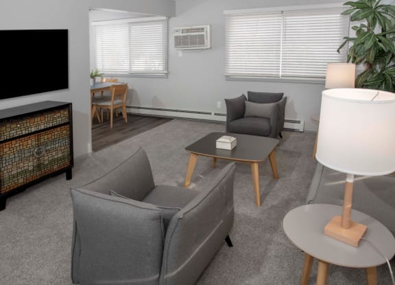 2 bedroom 1 bath living room with chairs, tv and view into dining