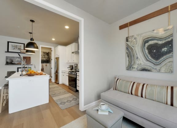 a living room with a couch and a kitchen