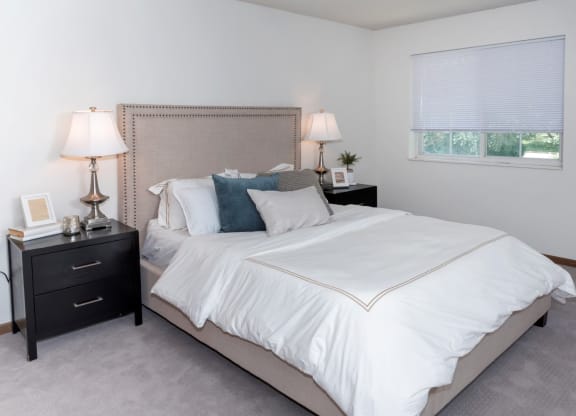 a bedroom with a bed and two nightstands