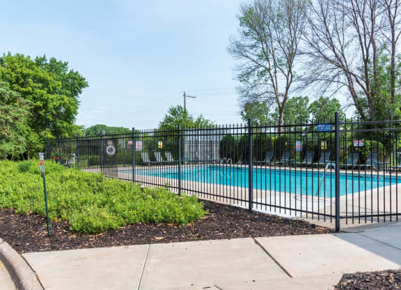 a swimming pool with a black fence in front of it