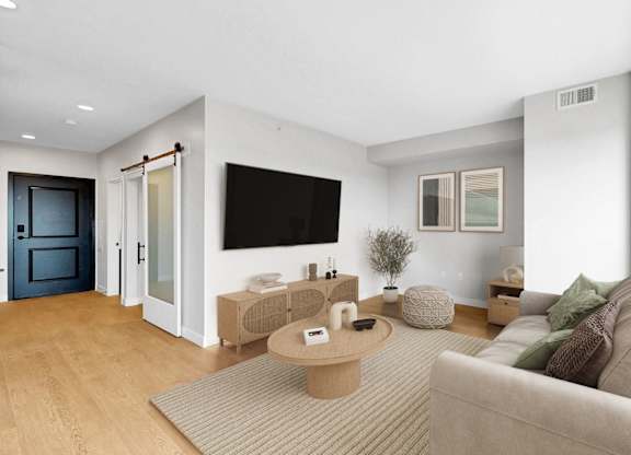 A modern living room with a grey sofa and a wooden coffee table.