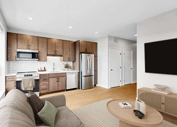 A modern kitchen with wooden cabinets and a grey sofa.