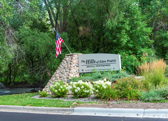 a stone monument with a sign that says the hills of clear picture with an american flag