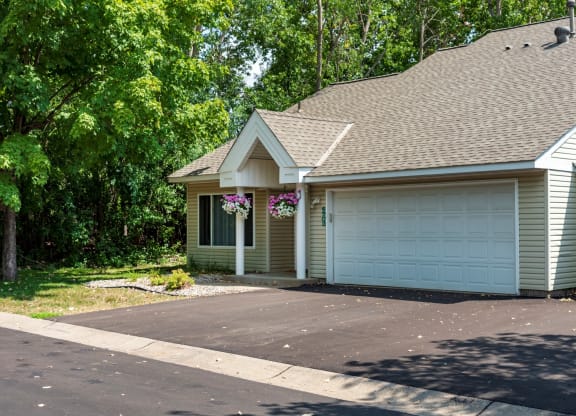 a house with a garage and trees in the background