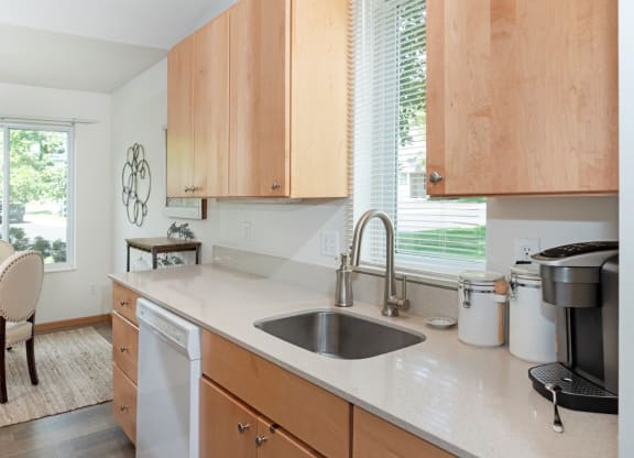 a kitchen with white countertops and wooden cabinets