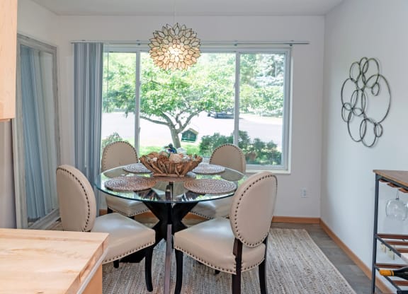 a dining room with a large window and a chandelier