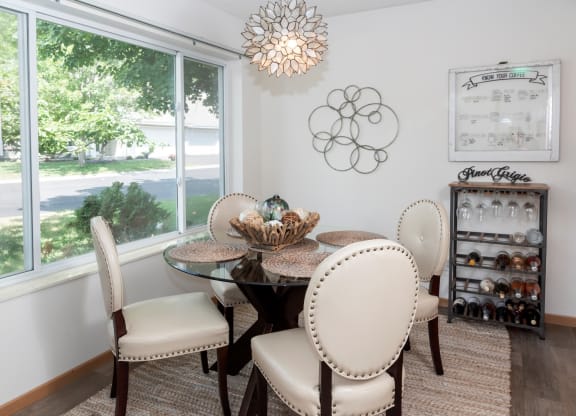 a dining room with a table and chairs and a large window
