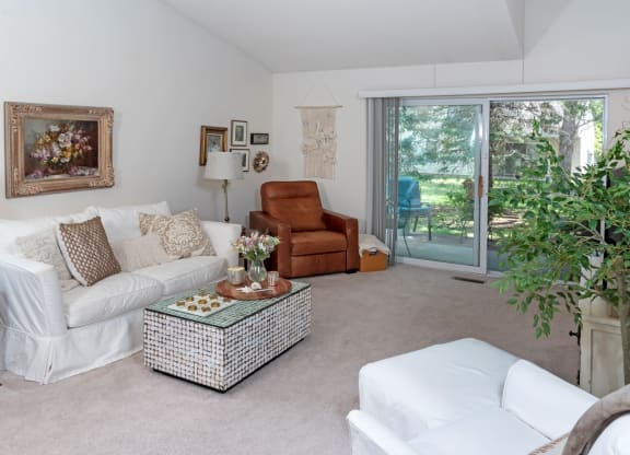 a living room with a white couch and a brown chair