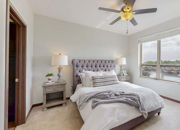 A bedroom with a large bed and a ceiling fan. at Lake Jonathan Flats, Chaska, MN, 55318