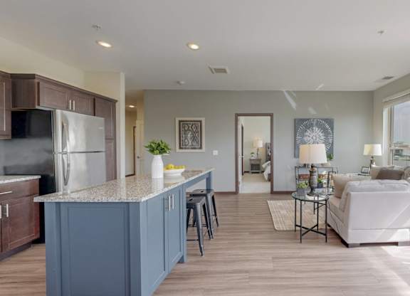 A modern kitchen with a blue island and white appliances. at Lake Jonathan Flats, Minnesota, 55318