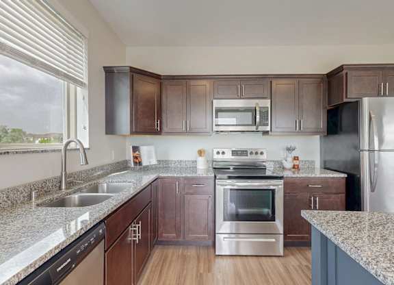 A kitchen with brown cabinets and stainless steel appliances. at Lake Jonathan Flats, Minnesota