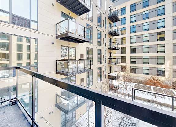 A modern building with balconies and glass railings.