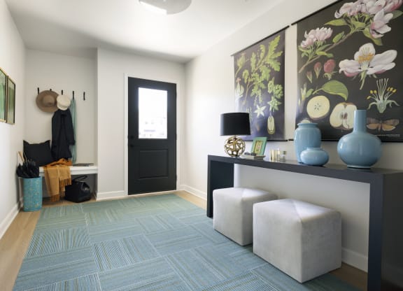 a living room with a blue rug and a black door