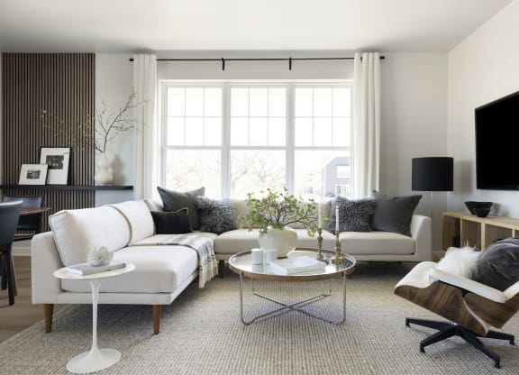 a living room with white furniture and a large window
