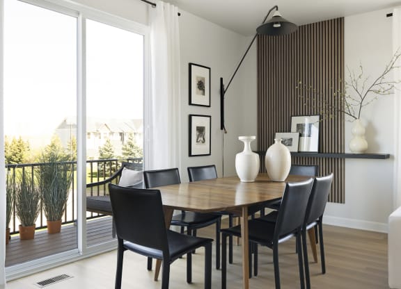 a dining room with a wooden table and black chairs