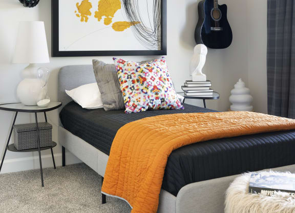 a bedroom with a bed and a guitar on the wall