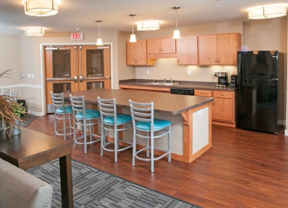 Kitchen with Full Sized Refrigerator, Dishwasher and Sink in Community Room of Apartments in Carver, MN