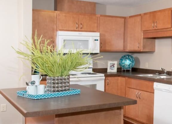 Carver Crossing Apartment Kitchen with Medium Wood Cabinetry and Large Center Island