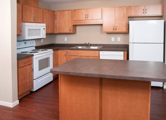 Carver Crossing Kitchen with White Appliances and Wood Cabinetry
