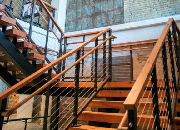 Chandelier Hanging Above Winding Wooden Stair Case at 700 Central Apartments, Minneapolis, MN