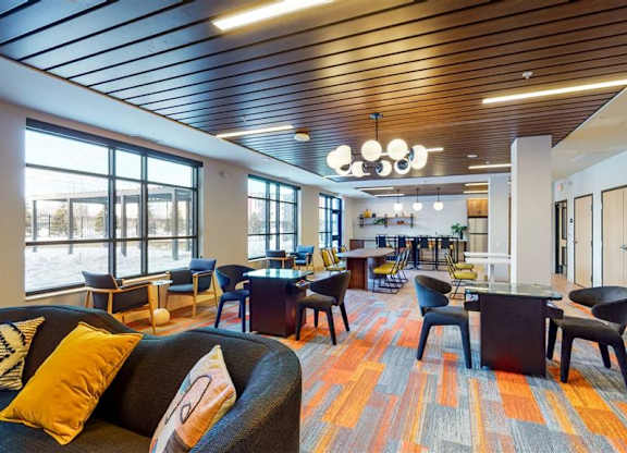 A modern office space with a variety of seating options and a colorful carpet at The Bessemer at Seward Commons Apartments, Minneapolis, MN,  55404